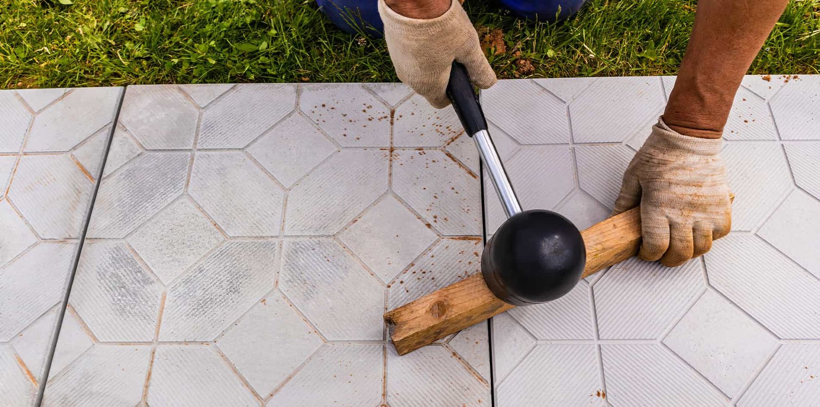 Fachmann bei der Verlegung von Pflastersteinen in einem Garten, um einen neuen Weg zu gestalten